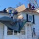 Construction crew removing and replacing an old roof