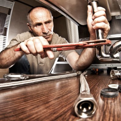 Plumber at work on pipes