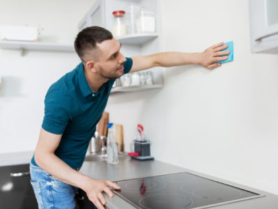 Man cleaning kitchen walls