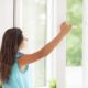 Woman opening window to let in fresh air and improve indoor air quality