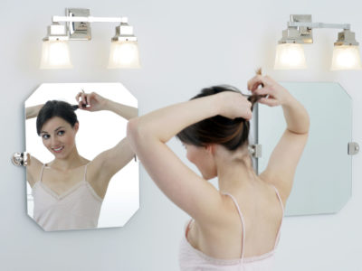 Bright bathroom with woman looking in mirror