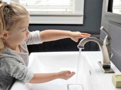 Child using touchless bathroom sink faucet